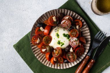Italian caprese salad with sliced tomatoes, mozzarella, basil, olive oil on a light background. Top view. Healthy food. Italian salad.