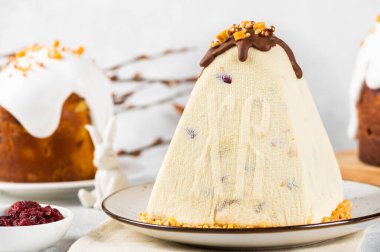 Geleneksel süzme peynir Paskalya Paşası ve beyaz masada yumurtalar. Rus Paşası. Paskalya tatlısı. Paskalya masası. Durgun hayat. Süzme peynirli tatlı