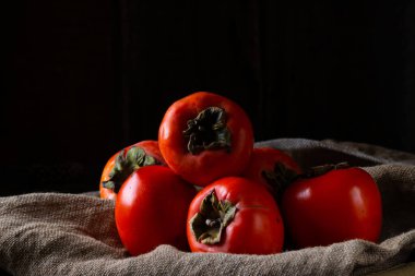 Ahşap arka planda olgun hurma. hurma eriği ya da Sharon meyvesi. Kaki hurma meyvesi. Yerel yemek..