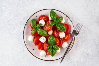 Dilimlenmiş domatesli İtalyan caprese salatası, mozzarella, fesleğen, koyu arkaplanda zeytinyağı. Üst Manzara. İtalyan yemeği. Sağlıklı salata. Yaz yemeği.