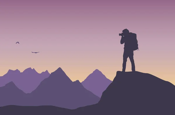 カメラ付きの写真家観光客のフラットデザインイラスト 彼は岩の上に立って 夕方の空に山と空を飛ぶ鳥を撮影する ベクトル — ストックベクタ