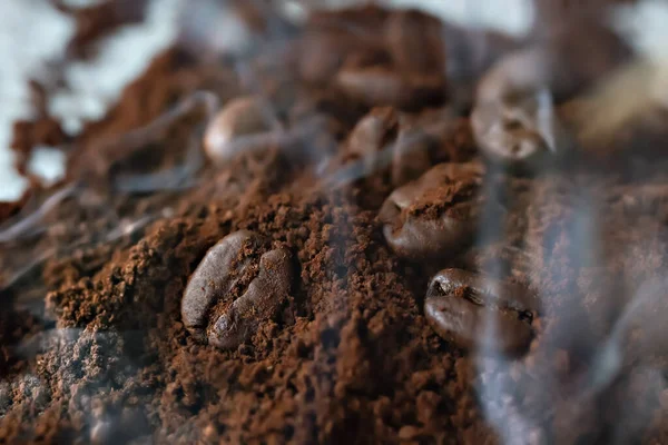 咖啡豆是在咖啡地面上 与烟熏煮咖啡 纵向立场 — 图库照片