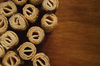 Çikolata kaplı waffle ruloları ahşap masa üzerinde, yatay düz manzara, kopyalama alanı