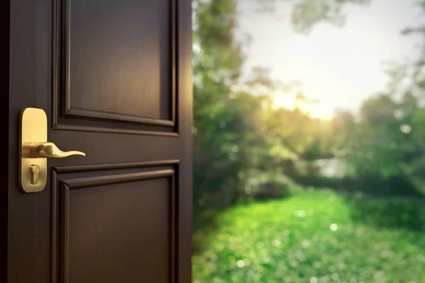 Üç boyutlu resimde, yeşil çimenler, ağaçlar ve çalılarla bahçeye açılan kapı görülüyor.