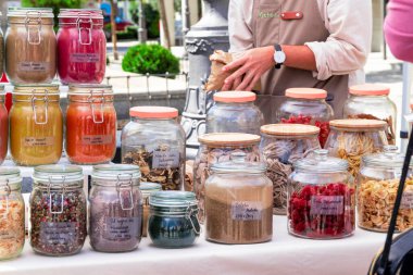 Sokak pazarındaki baharat tezgahında müşteriye hizmet eden bir tezgahtar.