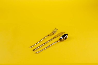 Sarı arka planda kaşık, çatal, bıçak. Yüksek kalite fotoğraf