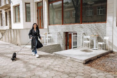 Güzel kız manken şehirde köpeği gezdirir. Yüksek kalite fotoğraf