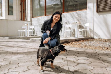 Güzel kız manken şehirde köpeği gezdirir. Yüksek kalite fotoğraf