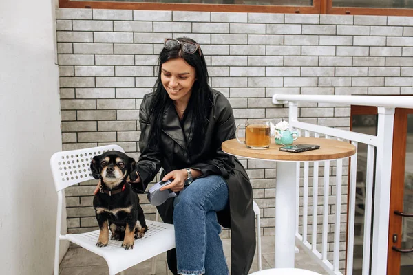 美少女モデルは黒犬と一緒に路上のカフェで食事をします 光の背景 高品質の写真 — ストック写真