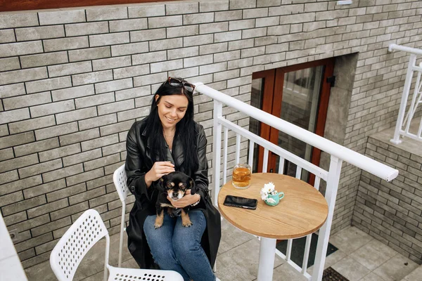 美少女モデルは黒犬と一緒に路上のカフェで食事をします 光の背景 高品質の写真 — ストック写真