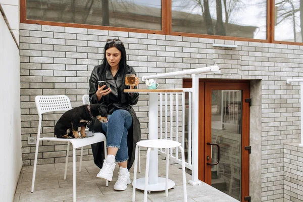 Vacker Flicka Modell Äter Ett Café Gatan Med Svart Hund Royaltyfria Stockfoton