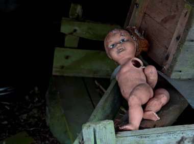 Parçalanmış uzuvları olan terk edilmiş eski bir bebek.