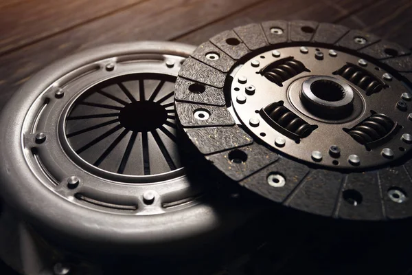 Siyah ahşap arka planda yeni araba debriyaj kiti. Kapat.