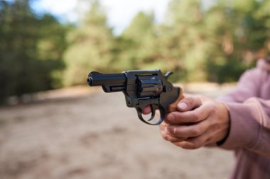 Kadın eli dışarıda tabancayı doğrultuyor..