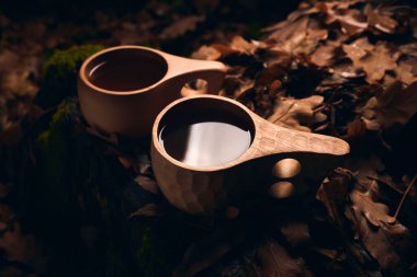 Sonbahar ormanında, gece vakti, Kuksa 'da, iki ahşap milli kupada çay içmek.