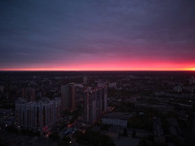 Kharkiv şehrinin arka planında kırmızı günbatımı gökyüzü yukarısı manzarası var.