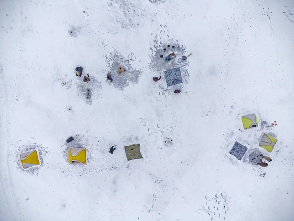 冬天在一个结冰的湖上钓鱼 五彩缤纷的钓鱼帐篷装在湖面的冰上 空中景观 — 图库照片