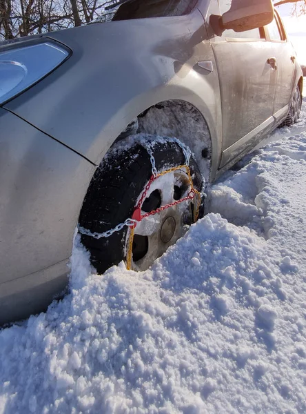 snow chain on a wheel in deep snow in winter road