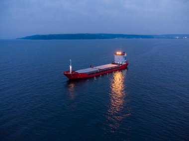 Geniş bir kargo gemisi tanker taşıyıcısı, geceleri tepeden aşağı hava manzaralı..