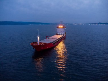 Geniş bir kargo gemisi tanker taşıyıcısı, geceleri tepeden aşağı hava manzaralı..