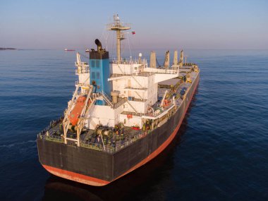 Büyük bir kargo gemisi tanker taşıyıcısı, gün batımında tepeden aşağı hava manzaralı..