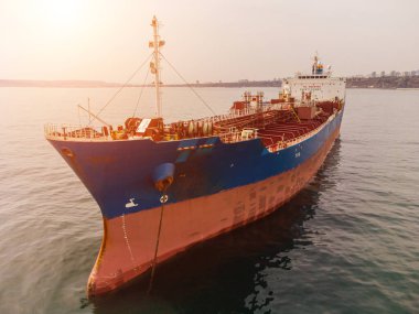 Büyük bir kargo gemisi tanker taşıyıcısı, gün batımında tepeden aşağı hava manzaralı..