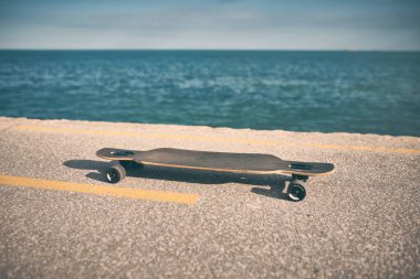 İnsanlar olmadan, asfaltta, denizin arka planına çifte tekme.