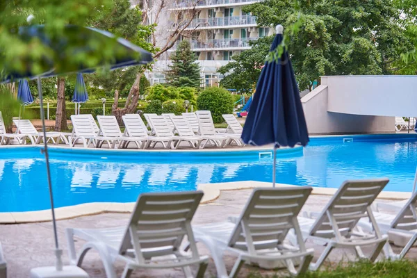 Hotel swimming pool umbrella and chairs, no people