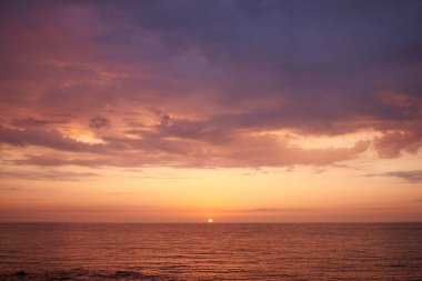Yaz günü güneşin doğuşunda denizin üzerinde güzel bulutlar.
