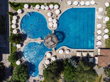 Aerial top view of happy young people relax at luxury resort on sunny day. View from drone