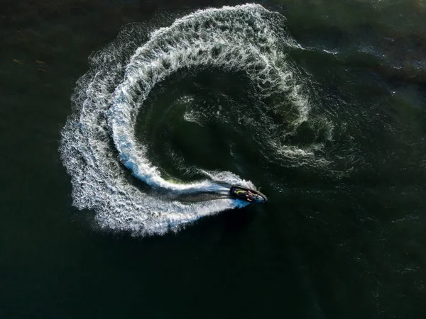 Aerial top view of a scooter at the lake surface. Luxury floating boat on water at sunny day.