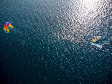 Aerial top view of the boat and parachute in the sea resort
