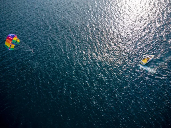 Aerial top view of the boat and parachute in the sea resort