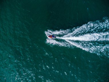 Aerial top down view of floating scooter on blue sea at sunny day.