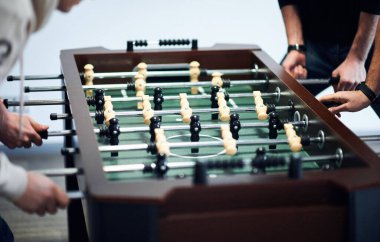 group of young people playing in table football at office