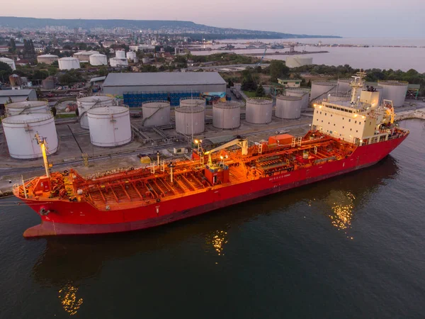 Aerial top view of oil ship tanker and lpg ship at industrial port at sunset