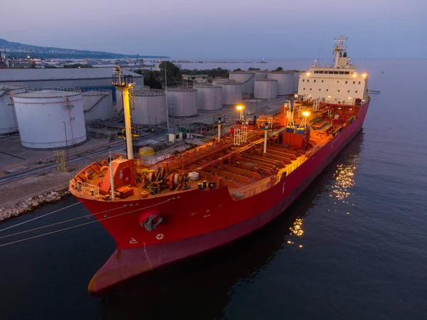 Aerial top view of oil ship tanker and lpg ship at industrial port at sunset