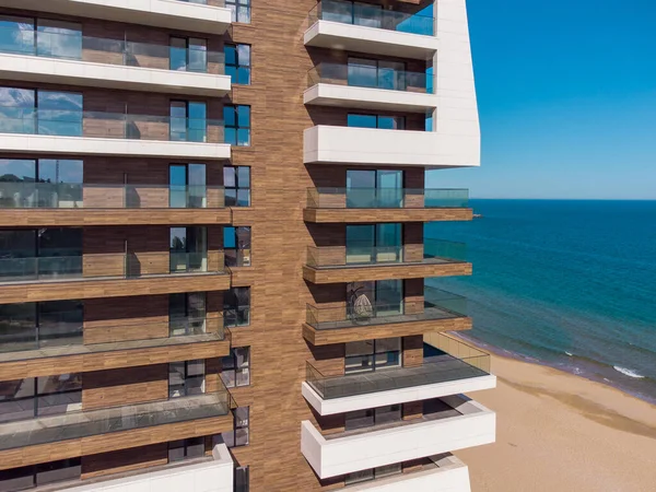 Perspective of high-rise condominium building with sea view background, aerial view