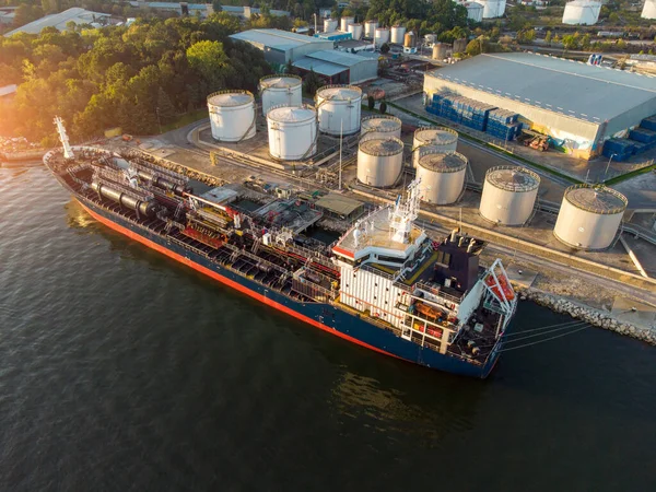 Aerial view of Chemical industry storage tank and tanker ship entering to the oil terminal, drone video