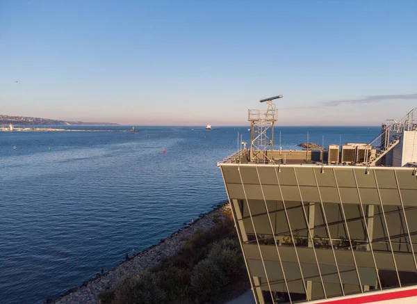 Control tower of ships with big cargo ship entering the port at the evening, drone video
