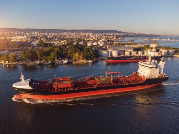 Aerial view of Chemical industry storage tank and tanker ship entering to the oil terminal, drone video