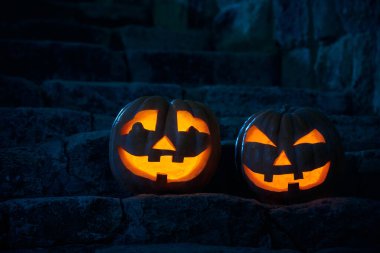 Cadılar Bayramı balkabakları, parlak ay ışığında eski bir şatonun bahçesinde fener çalıyorlar.