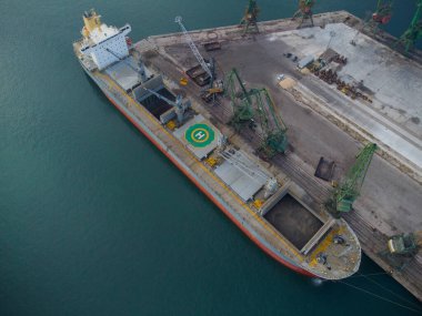 Büyük kargo gemisinin hava üst görüntüsü limanda kömür yüklü.