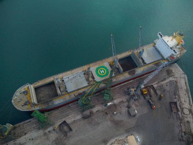 Büyük kargo gemisinin hava üst görüntüsü limanda kömür yüklü.