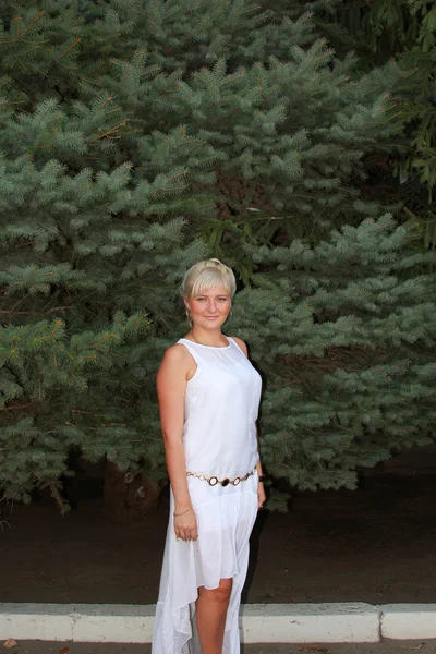 Une fille dans une longue robe blanche près de l'épinette — Photo