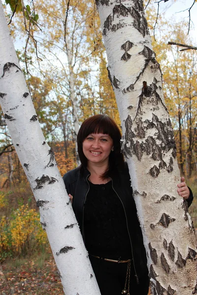 Flickan i en höst skog nära björkar — Stockfoto