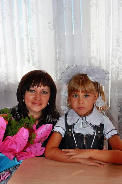 Young mother with her daughter at her desk with a bouquet of flo — Stock Photo, Image