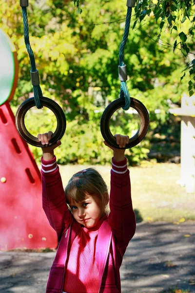 Girl hanging on the rings — Stock Photo, Image