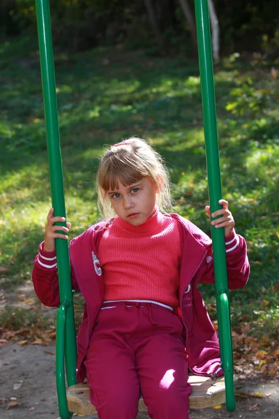 La fille en costume de sport sur une balançoire — Photo