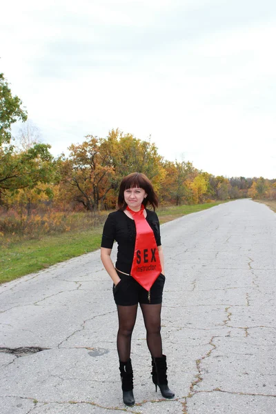 Girl standing on the road in a red tie — Stock Photo, Image